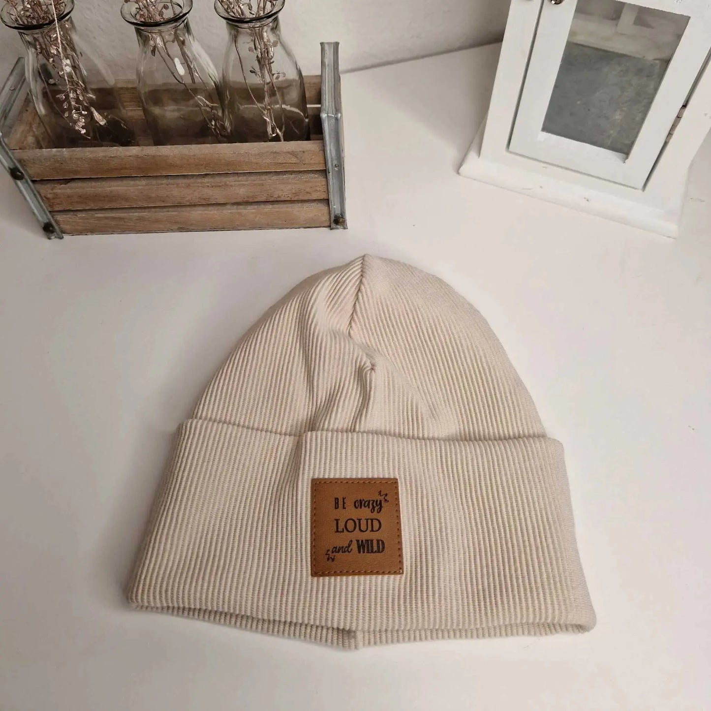 Beige hipster beanie for kids, size 46, featuring "Be crazy loud and wild" label.