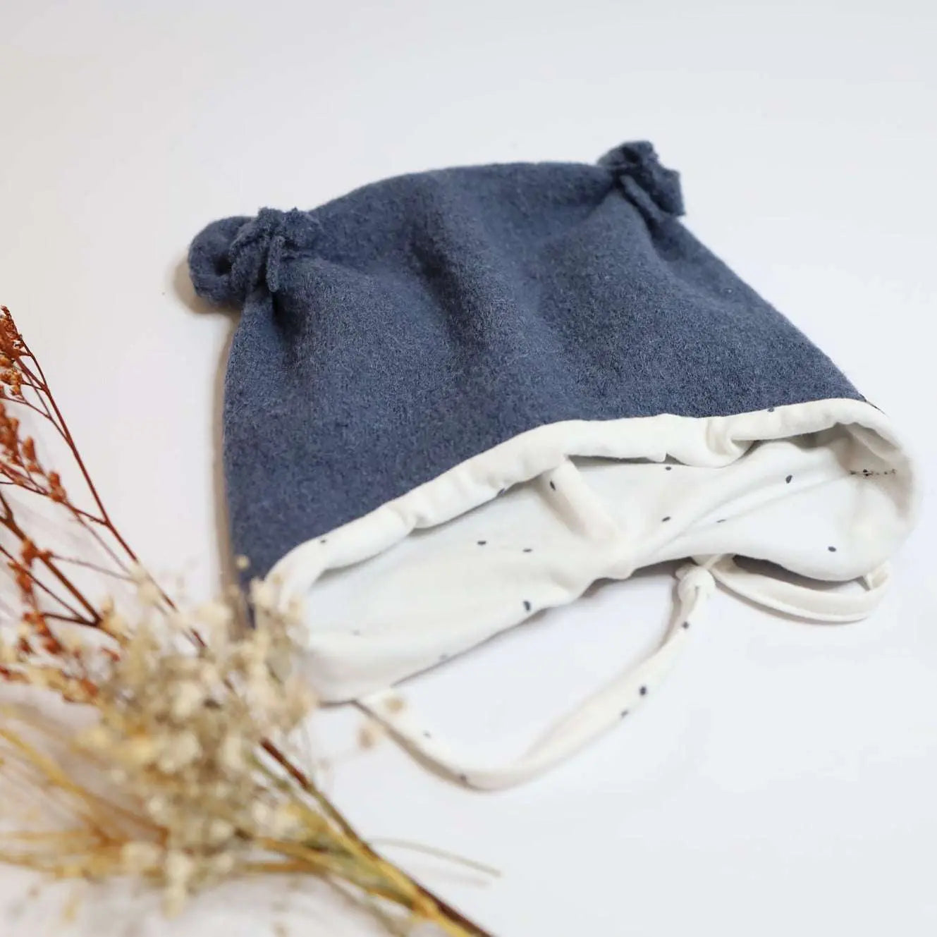 Blue wool hat with ear flaps, jersey lining, and ties.