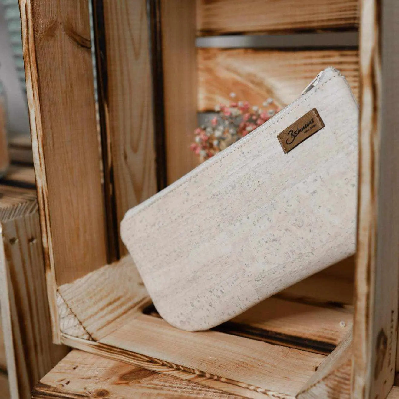 Kleine Kosmetiktasche Ecru aus Stoff in Holzregal platziert.