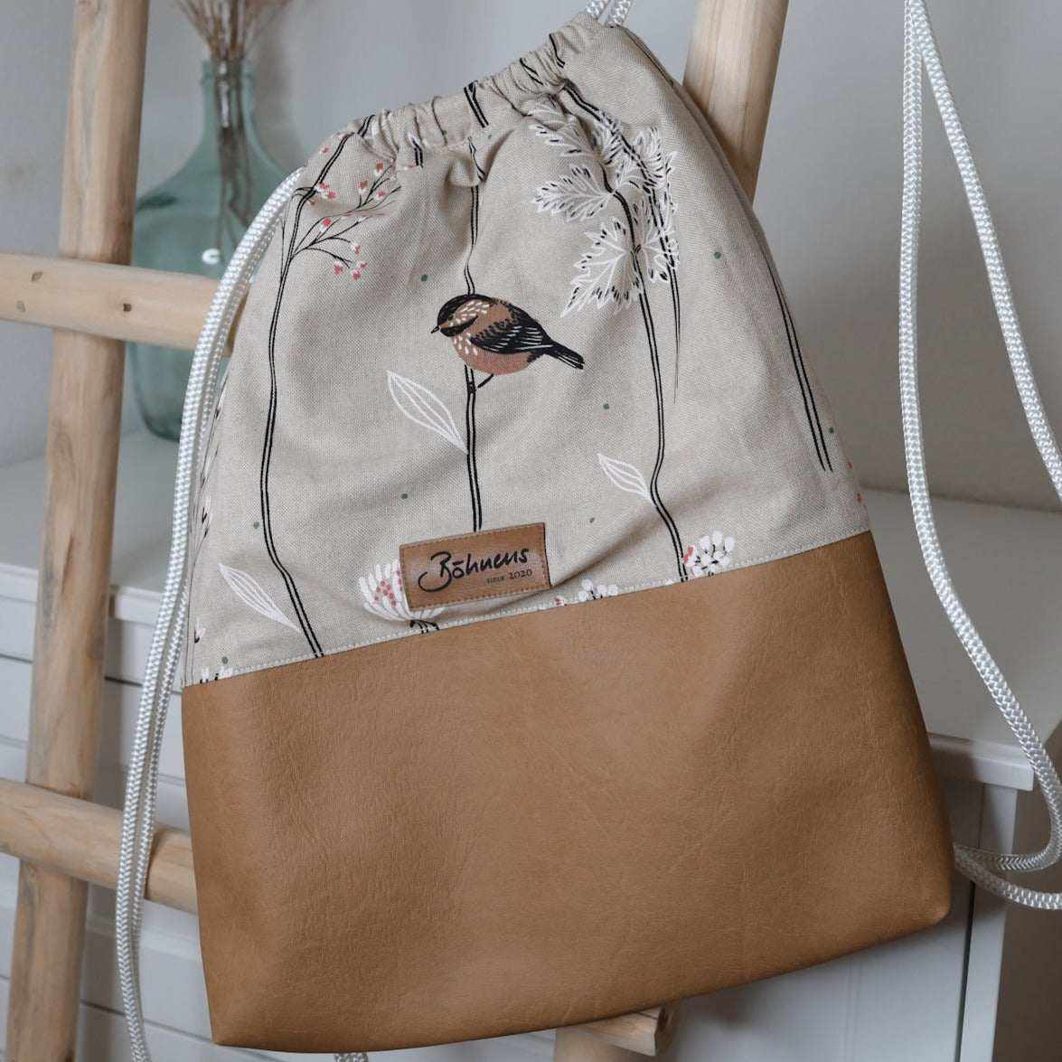 Sportbag "Vögelchen"Der hochwertige Sport-Bag "Vögelchen" besticht durch sein innovatives Design. EDer leichte Canvasstoff passt perfekt zum dunkelbraunen Kunstleder. Der Bag verfügt zuSportbag "Böhnens