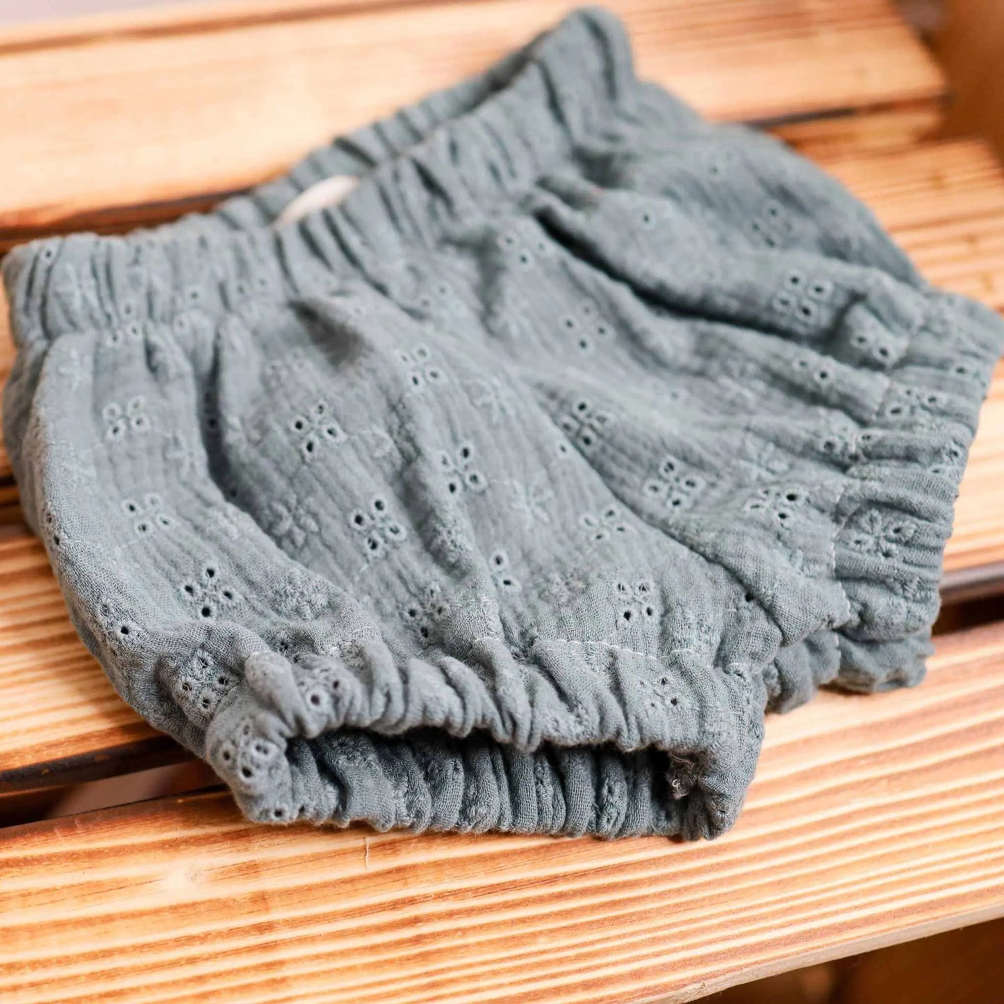 Bloomers aus Musselin mit Lochstickerei auf Holzbank.