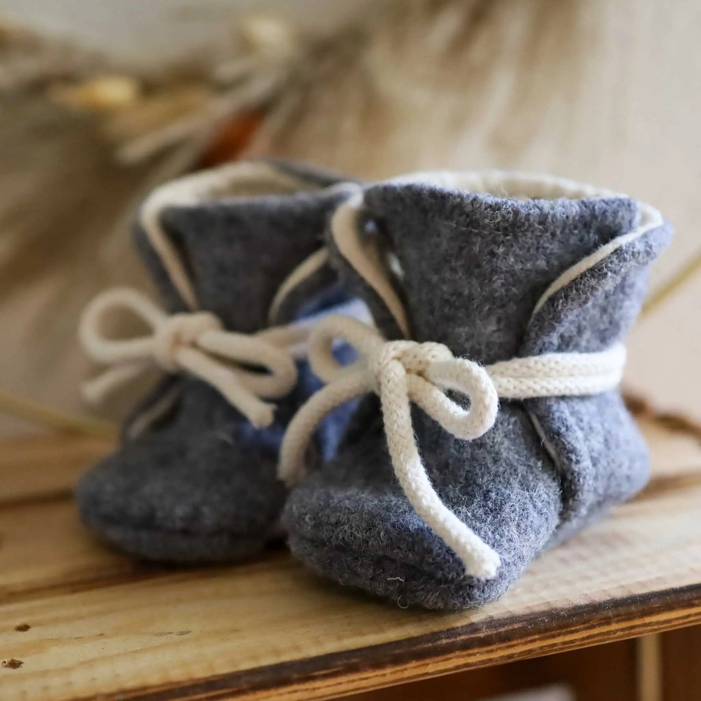 Handmade grey wool baby booties for warmth and comfort.
