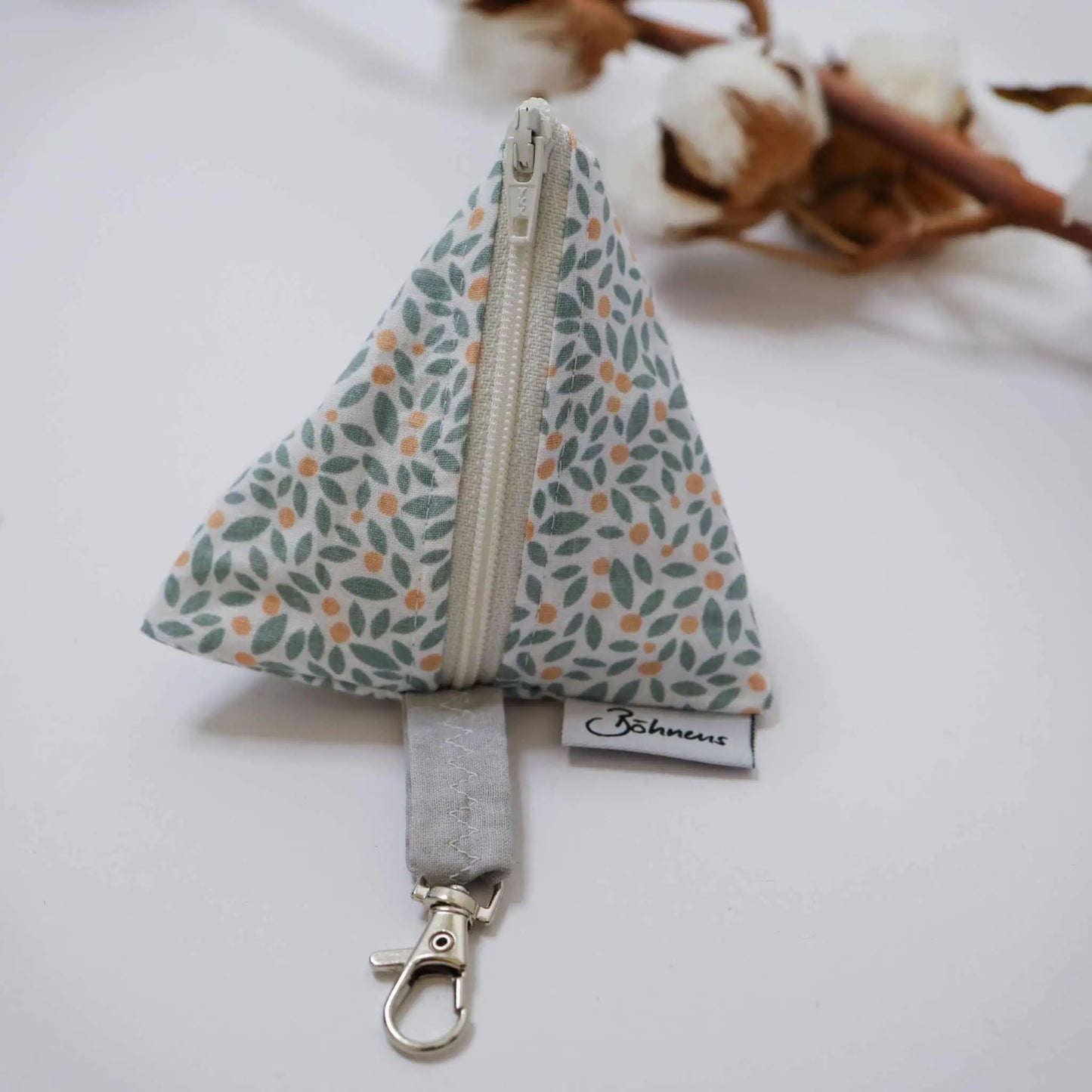 Triangle-patterned "Schnickschnack-Tasche Blätter" pouch with leaf design and zipper.