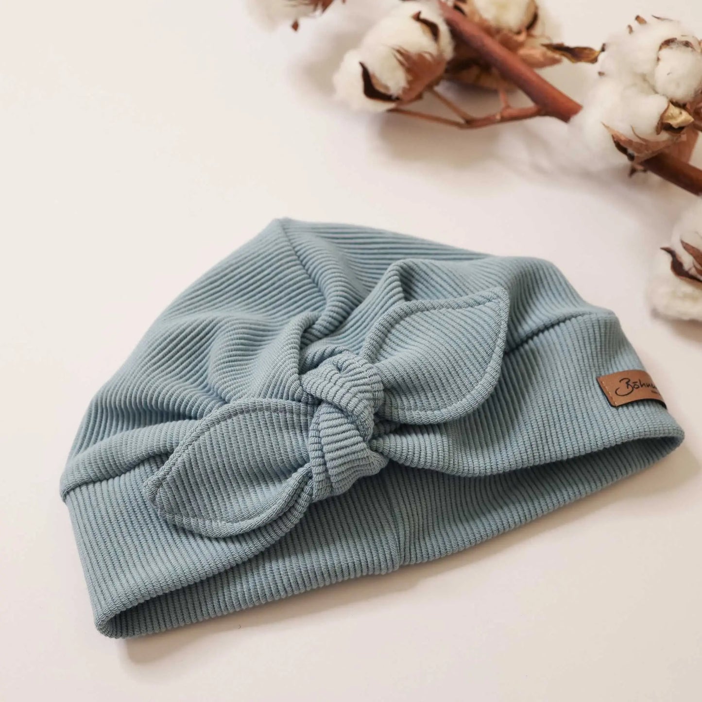 Turbanmütze in meergrün aus weichem Stoff mit Knoten-Design.