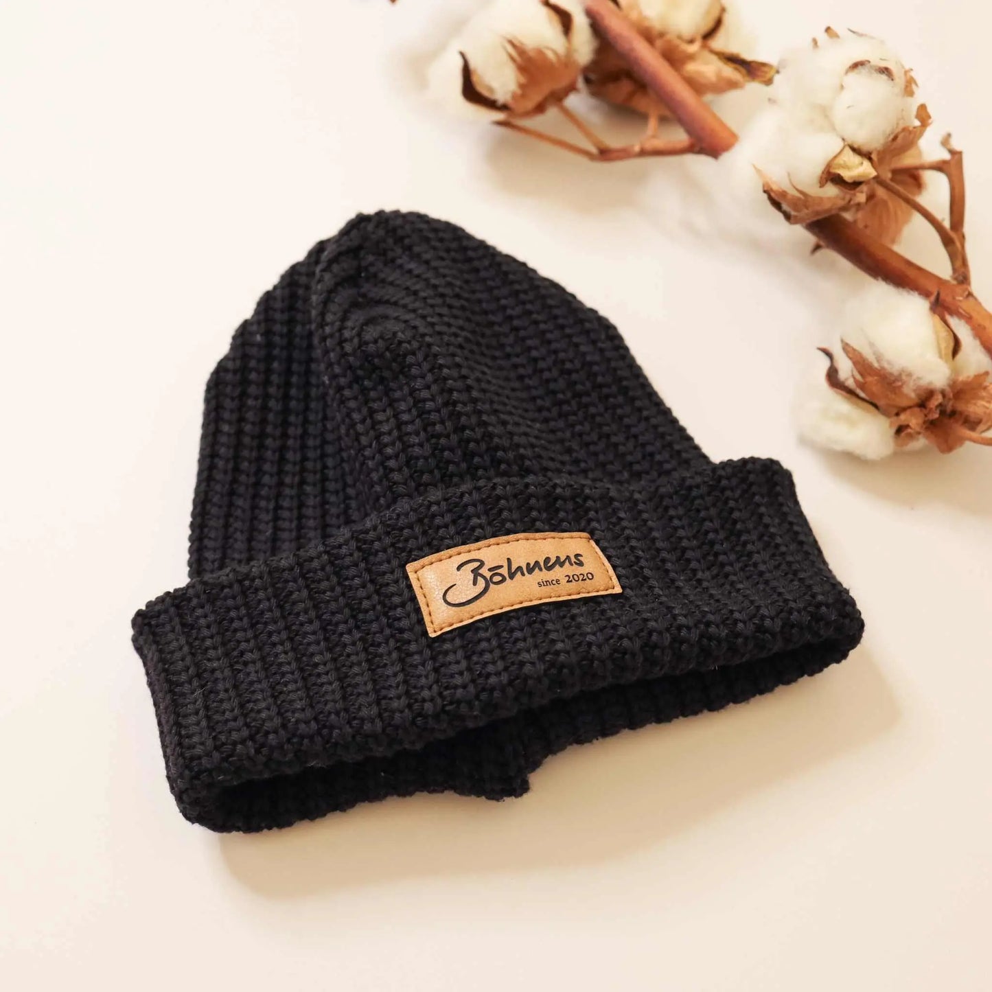Black chunky knit beanie without pompom, perfect for cold weather.