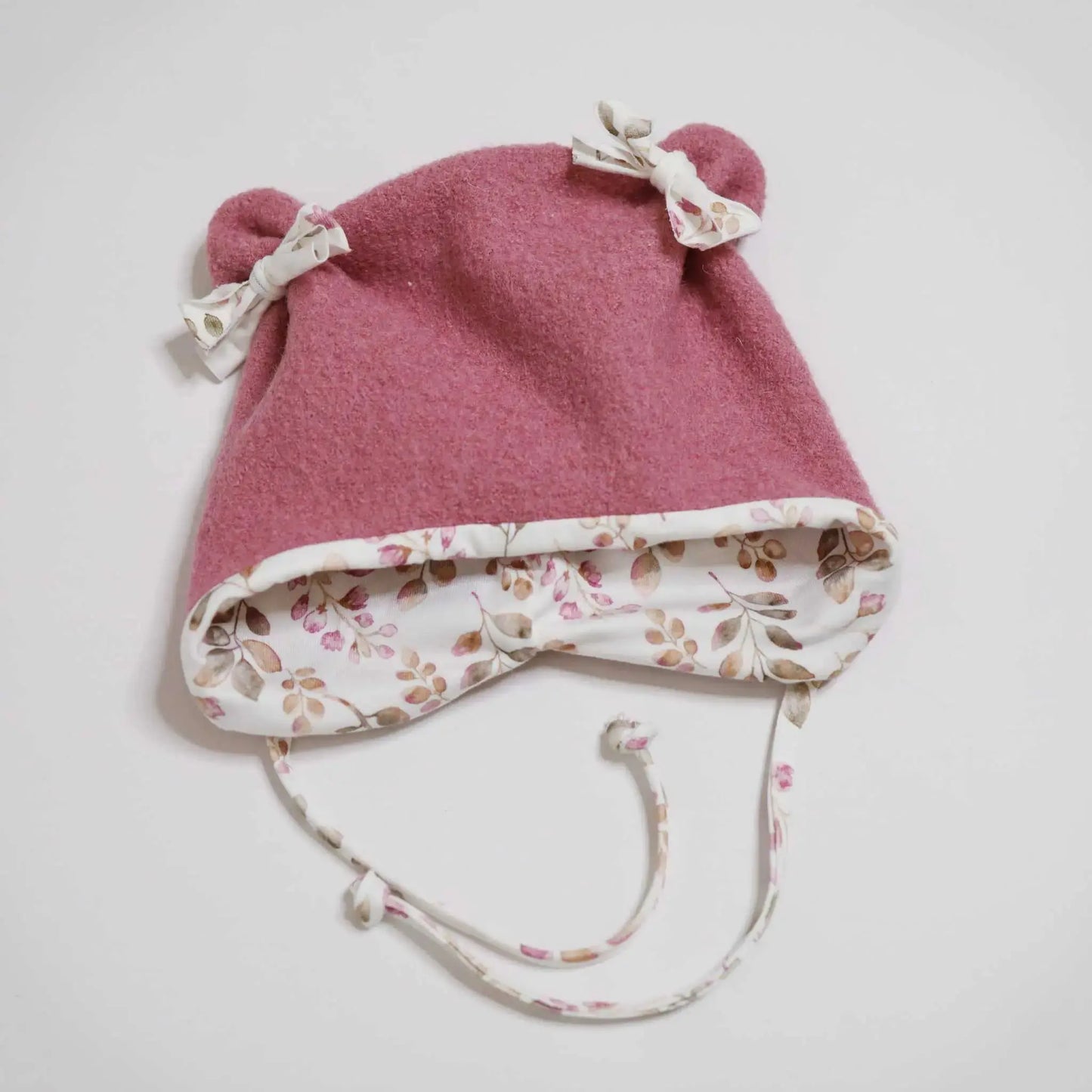 Pink woolly ear hat "Wollwalk Öhrchenmütze" with floral lining and ties.