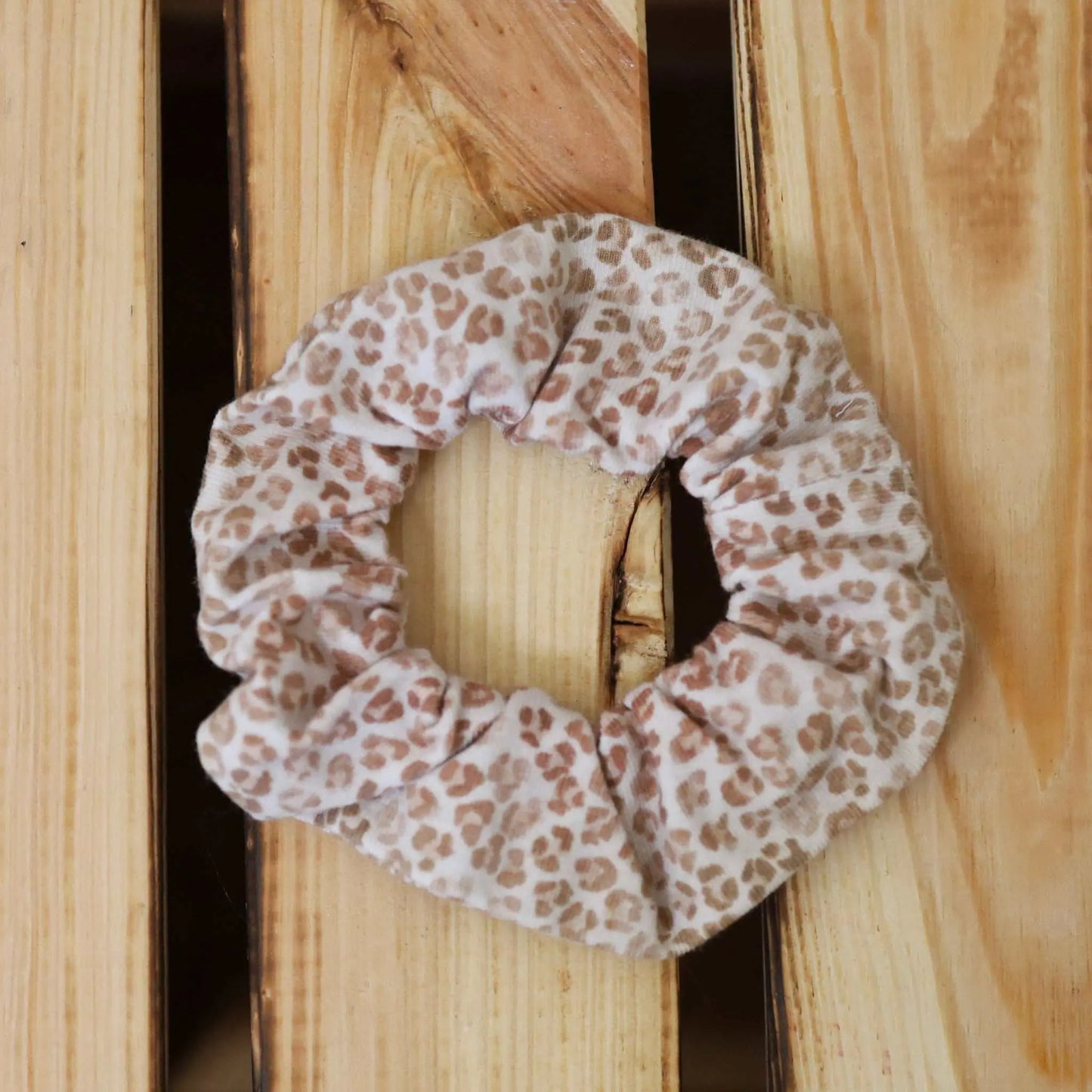 Scrunchie "Leo" with leopard print on wood background.