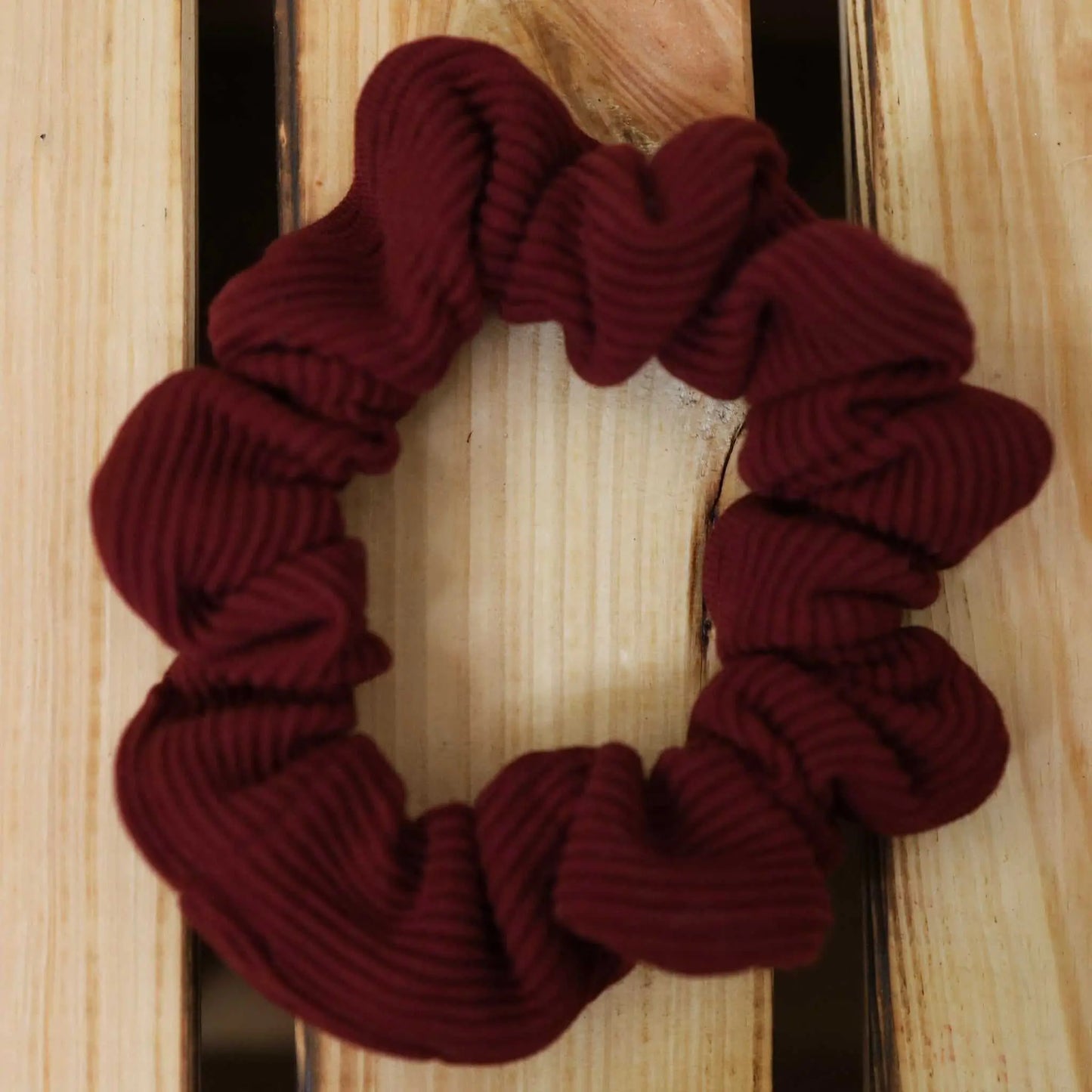 Scrunchie schmal in bordeaux on wooden surface, made from jersey RIB fabric.