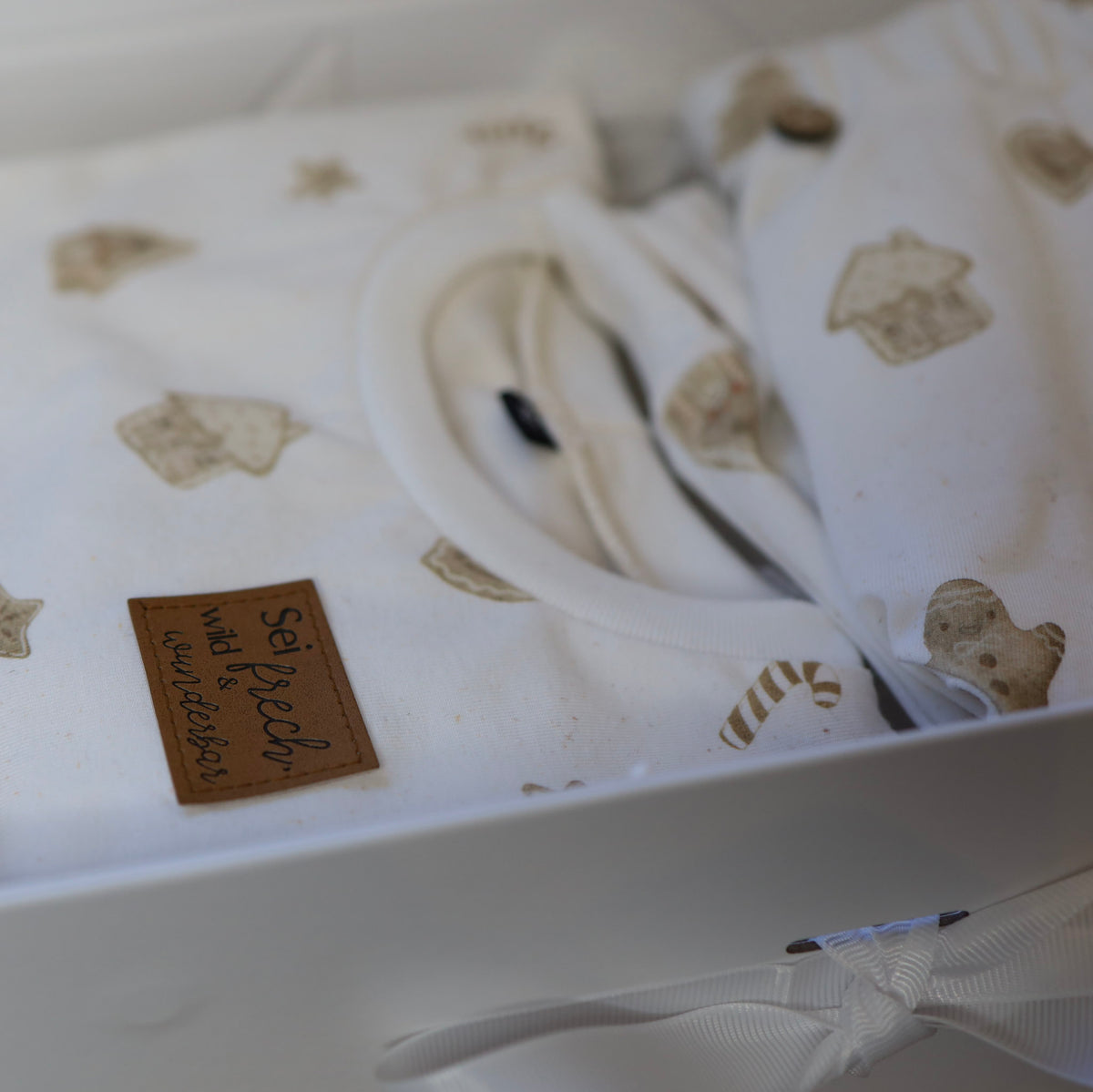 Baby Geschenkbox mit handgenähtem Oversize Pullover und Hose mit Lebkuchenmännchen und Sternen