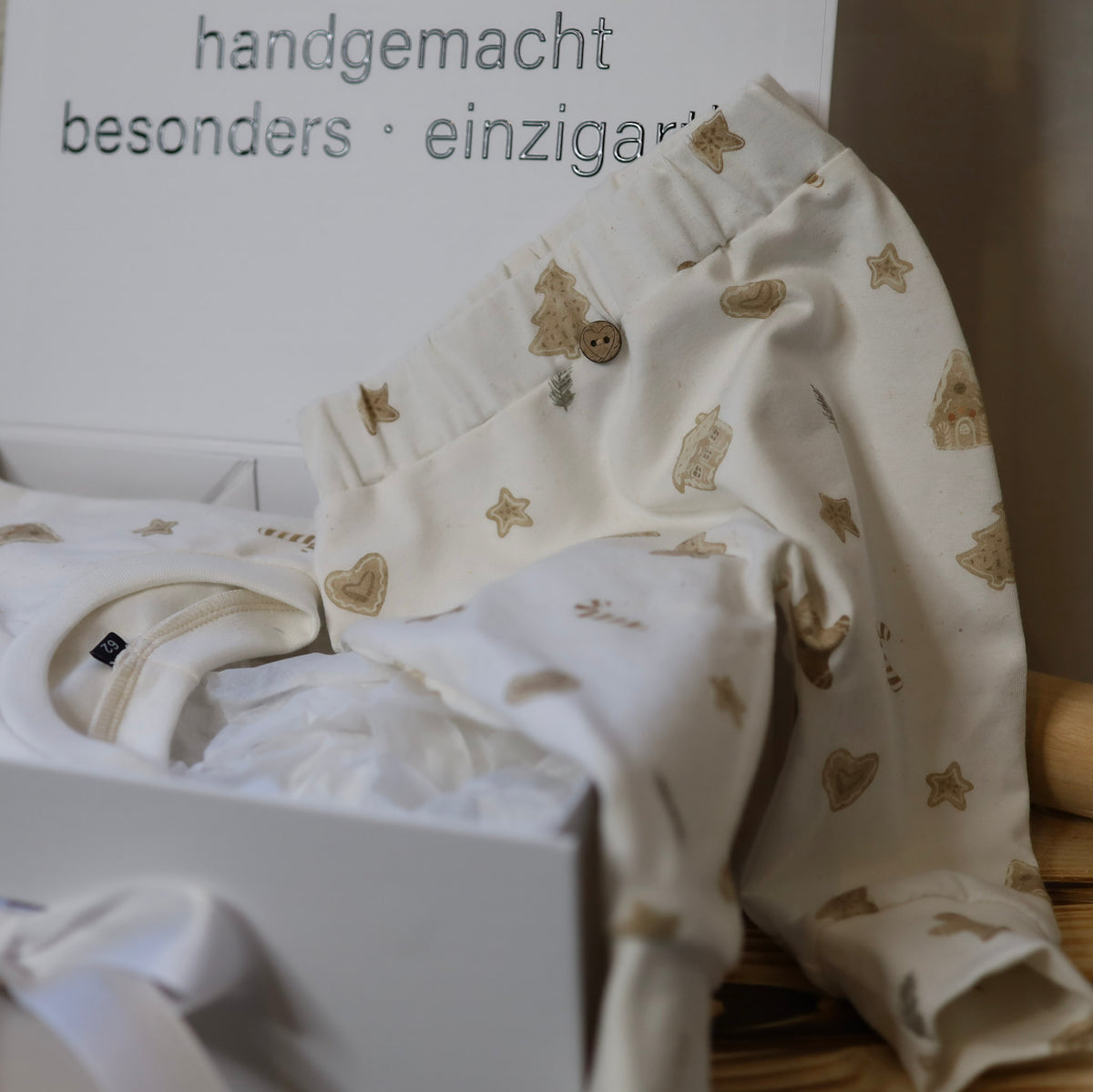 Baby Geschenkbox mit handgenähtem Oversize Pullover und Hose mit Lebkuchenmännchen und Sternen